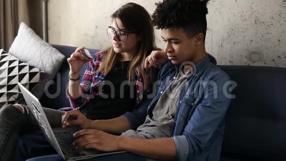 年轻快乐的一对两个嬉皮士用笔记本电脑在线订购食物视频的预览图