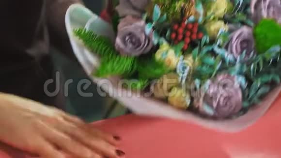 女人花店用纸包着花束特写视频的预览图