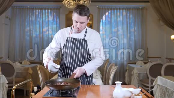 在餐厅的一个热煎锅上加入肝片的厨师烹饪弗拉姆贝式菜肴石油和酒精视频的预览图