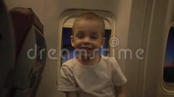 飞机窗上可爱有趣的小孩的肖像背景是日落视频的预览图