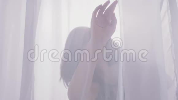 一个女人在薄纱后面的剪影靠近窗户日光50英尺视频的预览图