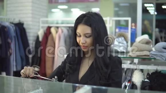 在一家服装店里挑选一件黑色衣服的漂亮女孩视频的预览图