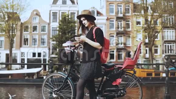 在老城桥上骑自行车的博客女士女性欧洲旅游类型环顾四周享受温暖的晴天4K视频的预览图