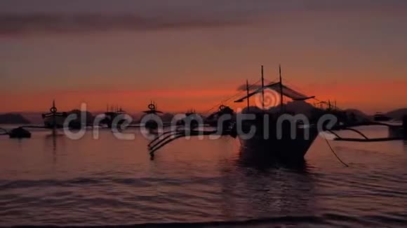 在日落时分拍摄菲律宾传统船只邦卡的万宝龙美丽的日落菲律宾的轮廓视频的预览图