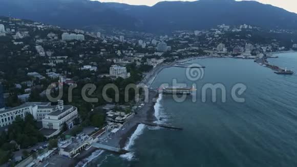 在群山的背景下海边的城市视频的预览图