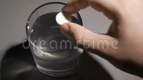 一个人把一块泡腾的药片扔进一杯水里视频的预览图