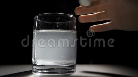 一个人把一块泡腾的药片扔进一杯水里视频的预览图