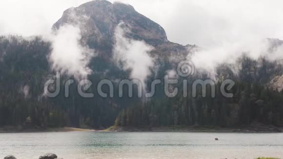 云雾缭绕的山湖景观库存蓝湖附近有茂密绿林的山低云视频的预览图