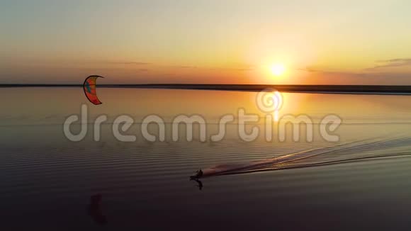 空中拍摄日落的河流那里的风筝翻滚视频的预览图