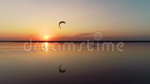 人争着一只橙色的训练风筝夕阳落在湖面上慢动作视频的预览图