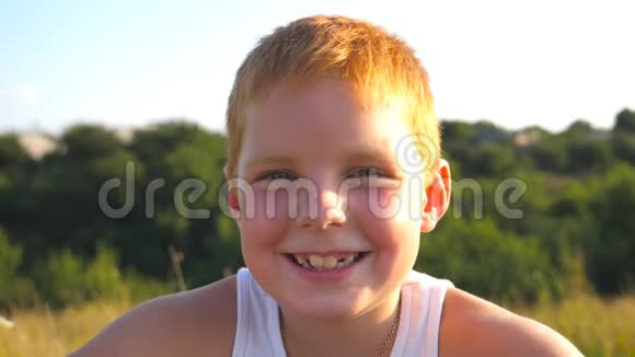 有雀斑的快乐红发男孩的肖像笑在户外可爱英俊的宝宝带着喜悦的心情看着镜头视频的预览图