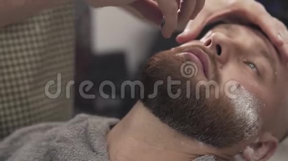 理发师剃胡子男子与直剃须刀在男性沙龙男性皮肤护理视频的预览图