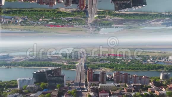鸟瞰大桥跨越宽河附近一座城市镜面视界效果媒体有绿色的夏季景观视频的预览图