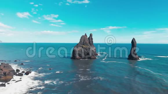 冰岛黑色火山海滩和海面上的岩石的鸟瞰图视频的预览图