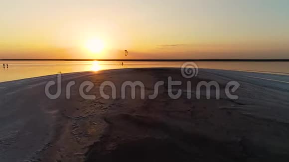 在一个孤独的人从事风筝冲浪的河口上空日落视频的预览图
