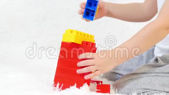 幼儿双手特写在彩色积木中玩耍坐在白色背景上孩子和玩具运动摄影机视频的预览图