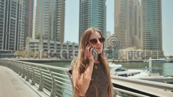 一个长发女孩走过迪拜在电话里交谈视频的预览图