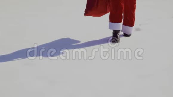 圣诞老人带着一袋礼物在雪地上散步视频的预览图
