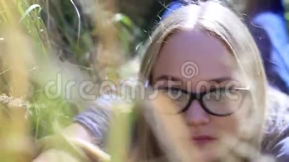 戴眼镜的小女孩躺在一片草地上视频的预览图