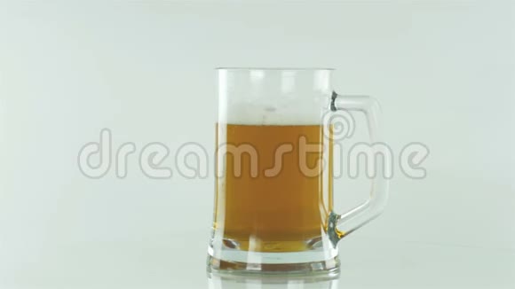 啤酒在白色背景的啤酒杯上隔离切断路径旋转成一个圆圈视频的预览图