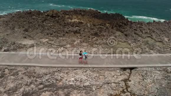 4K航天飞行无人机视频的年轻夫妇游客在野生岩石海滩巴厘岛视频的预览图