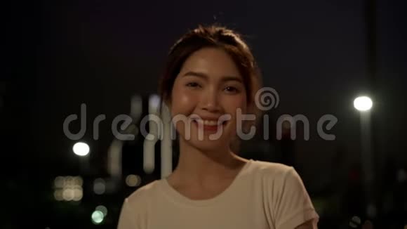 一个年轻的年轻的亚洲女人在市区的街头旅行时会高兴地微笑着视频的预览图