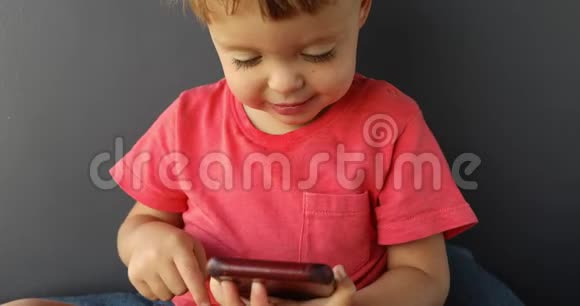 儿童敲击手机屏幕对现代技术感兴趣视频的预览图