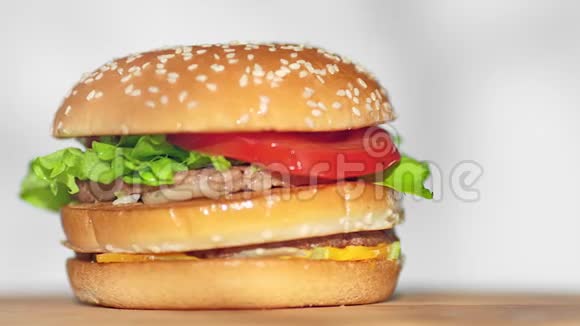 芝麻小面包上的鲜牛肉汉堡上面有芝士和生菜视频的预览图