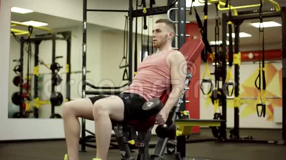运动员举起哑铃在健身房锻炼二头肌视频的预览图