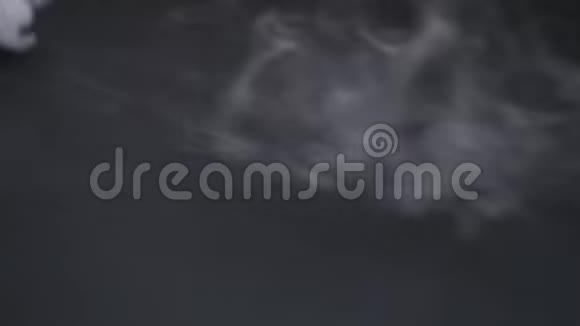 香烟烟雾在黑色背景下蔓延视频的预览图