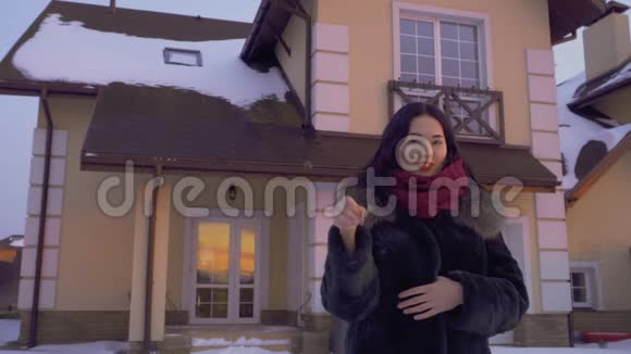 美丽的黑发女人拿着新房子的钥匙站在日落前视频的预览图
