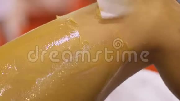 美容师用糖蜡去除腿部毛发美容和女性水疗中心视频的预览图