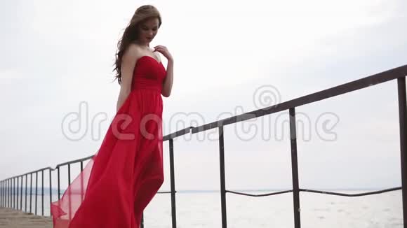美丽的女人穿着一件衣服站在海边她看起来忧郁而浪漫视频的预览图
