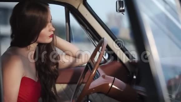 一个卷发的女人在车里双手放在方向盘上视频的预览图