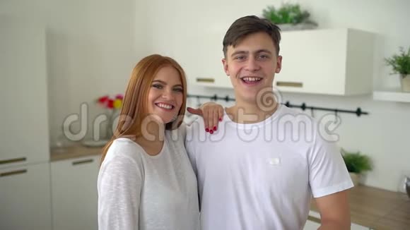 一对年轻夫妇在家厨房和摄像机说话慢动作视频的预览图