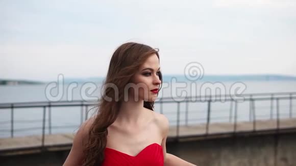 年轻可爱的女人穿着一件红色的衣服在夏天的大自然中视频的预览图
