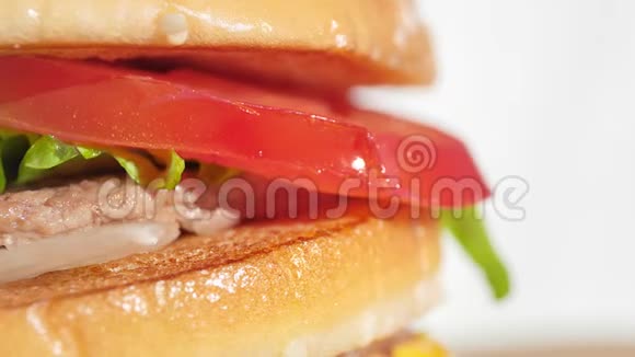 美味的红番茄片在开胃的新鲜汉堡旋转镜头视频的预览图