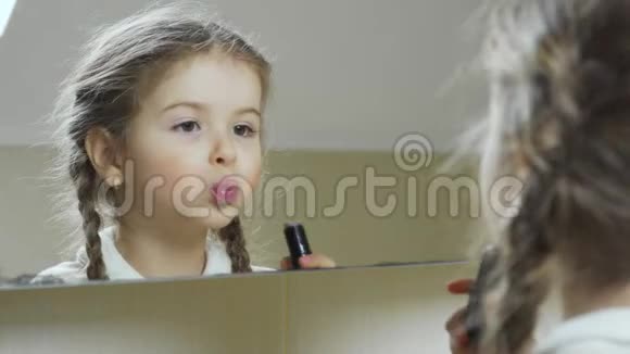 小女孩在镜子前涂上口红视频的预览图