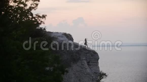 年轻女子在海底悬崖上表演舞蹈视频的预览图