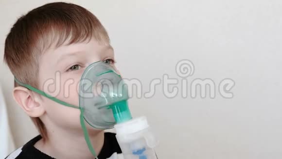 使用雾化器和吸入器进行治疗男孩通过吸入器面罩吸入前景视频的预览图