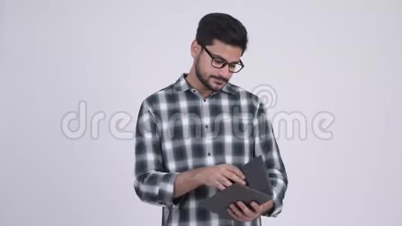 年轻快乐留胡子的印度男人读书视频的预览图