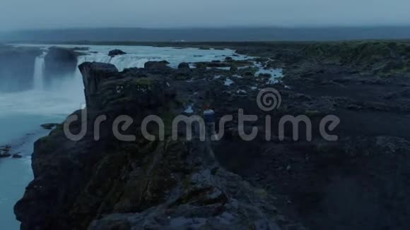 黄昏时分在史诗般的冰岛瀑布中孤独的人视频的预览图