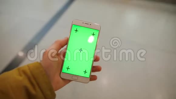 男性手持智能手机绿色屏幕穿过购物中心视频的预览图
