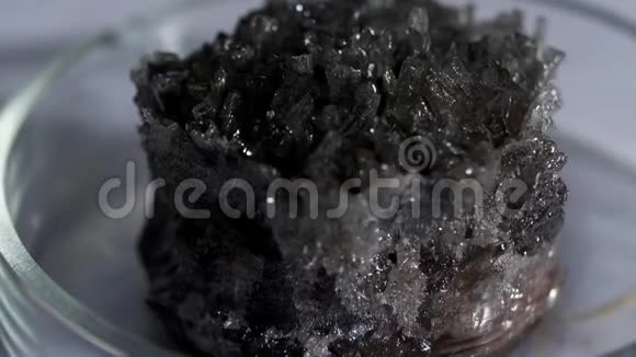 美丽不寻常的灰黑色水晶石锡石与金属光泽站在玻璃立场库存数据视频的预览图