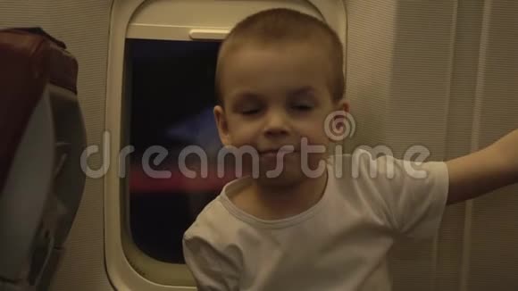 飞机窗上可爱有趣的小孩的肖像背景是日落视频的预览图