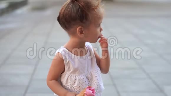 可爱的白种人小女孩喜欢在公园散步的华夫饼锥冰淇淋孩子吃明亮的冰淇淋视频的预览图