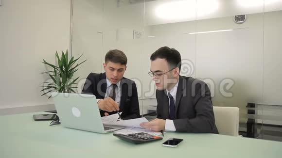 两名男性财务分析人员在联席会议室讨论年度报告视频的预览图