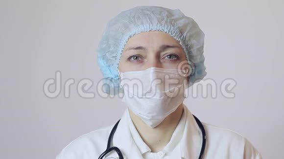 女外科医生的肖像医用面罩是保护脸特写医生看着摄像机视频的预览图