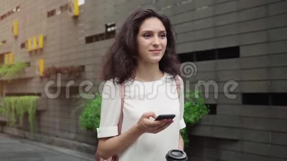 超级慢动作年轻的女士带着电话在城市里散步稳定射击视频的预览图