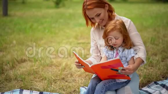妈妈和女儿在公园里看书视频的预览图